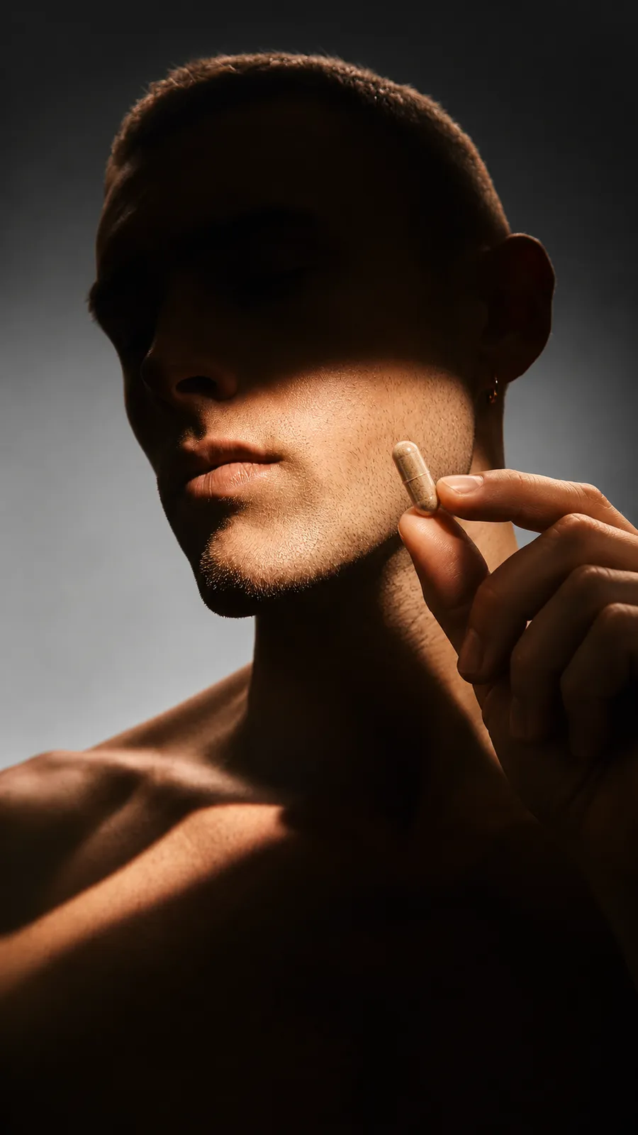 Man holding a capsule in warm light